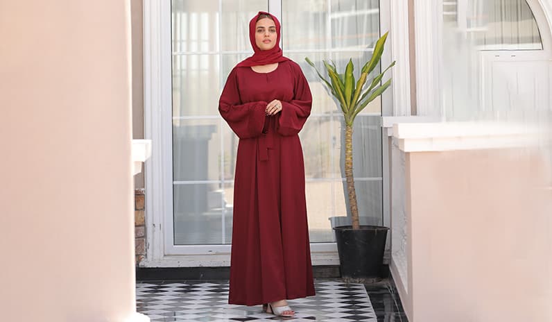 woman wearing maroon abaya dress