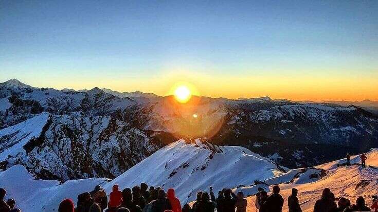 A breathtaking sunrise from the Kedarkantha summit, illuminating the snow-covered peaks.