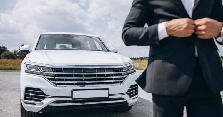 handsome business man by white car 4 1