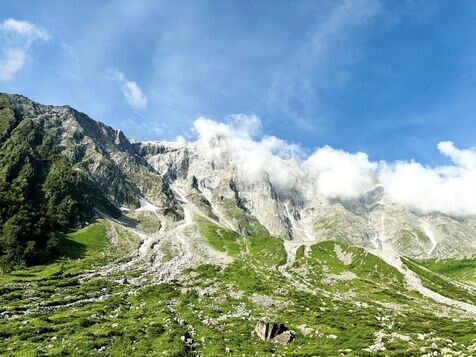 Beas Kund Trek with Lush Greenery and Mountain Hills Covered in a Thin Layer of Clouds During Summer.