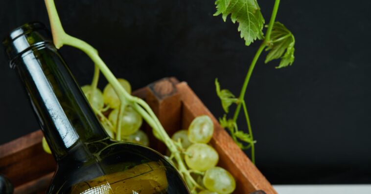 bunch grapes wine bottle white table close up high quality photo 1