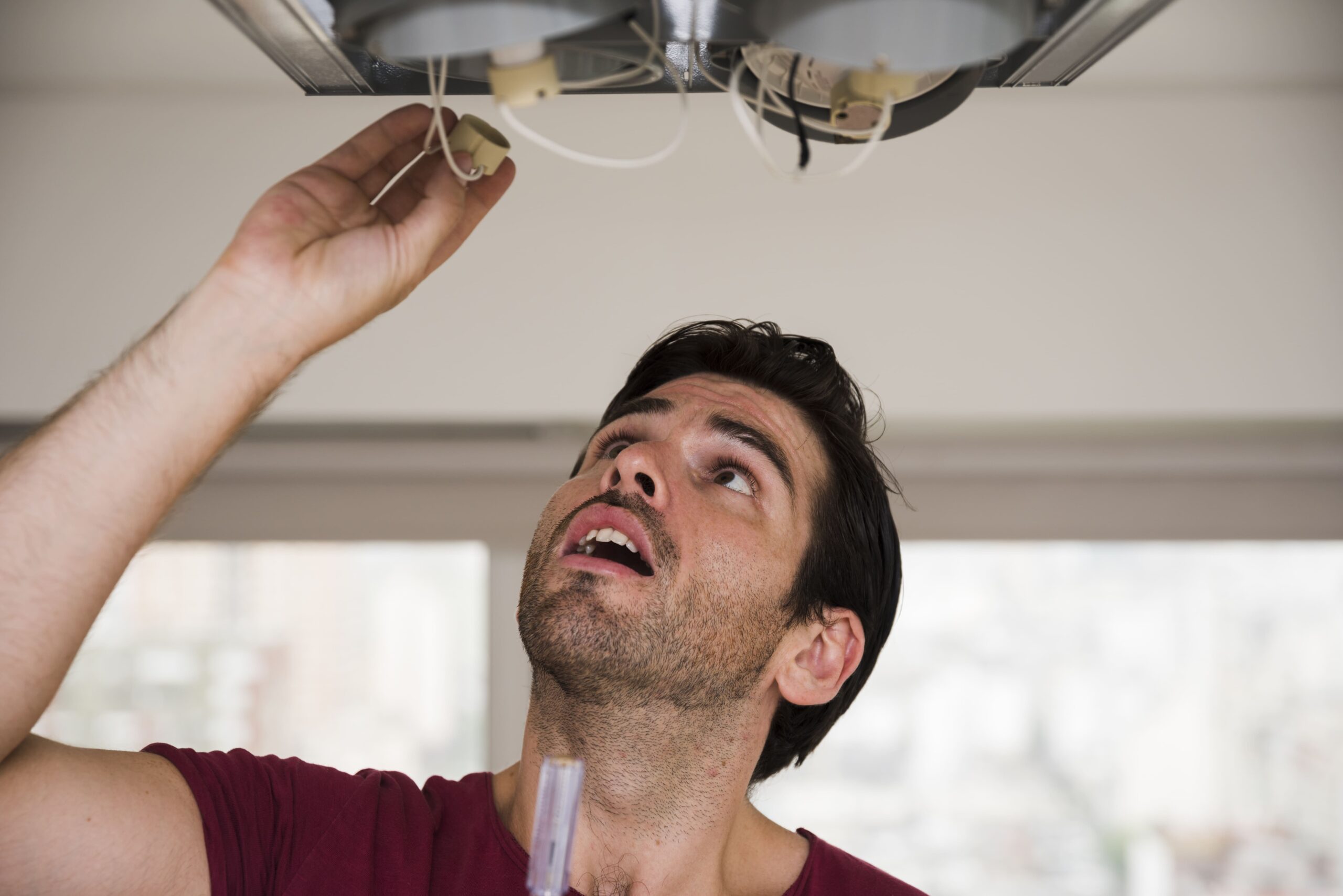 Professional Ceiling Fan Installation Brisbane – Trusted Local Experts 1 close up male electrician installing holder ceiling light 1 scaled
