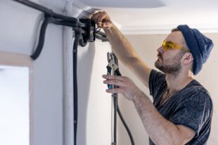 electrician is mounting electric sockets white wall indoors 1