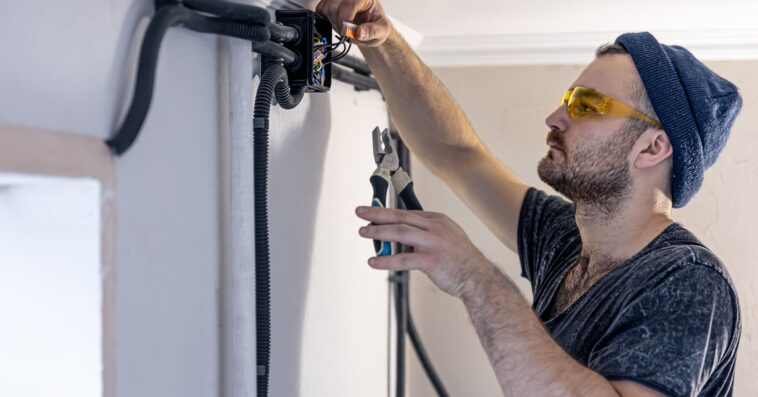 electrician is mounting electric sockets white wall indoors 1