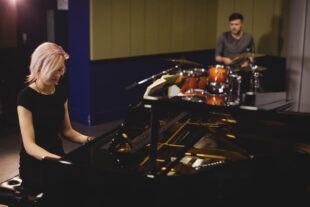 female male students playing piano drum set 2