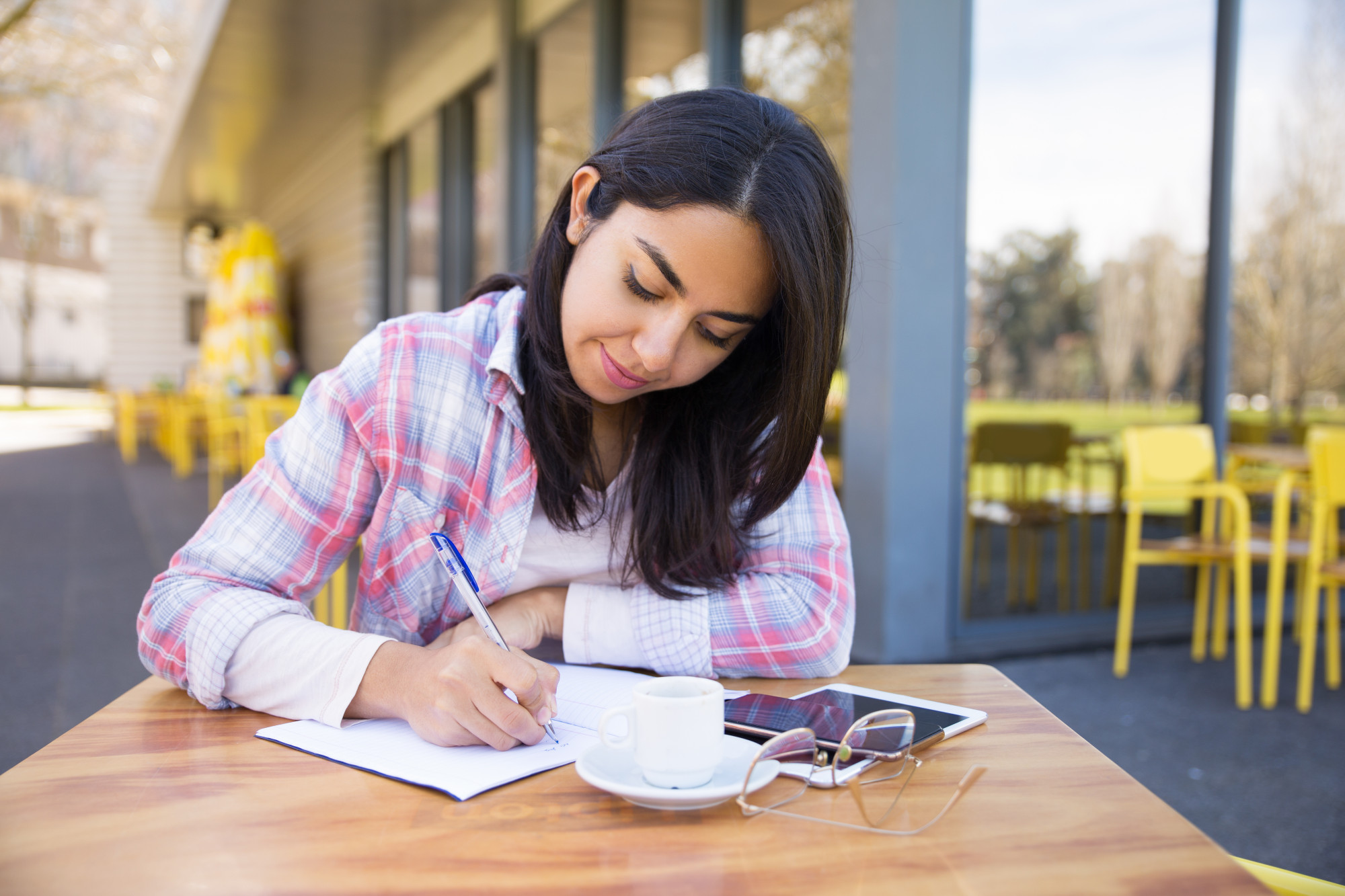 Hire Someone to Take My Verbal Reasoning Job Placement Exam Online 1 focused young woman making notes outdoor cafe