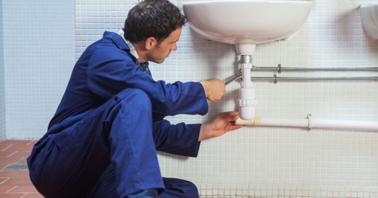 handsome plumber repairing sink 1