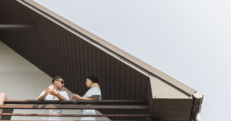 low angle view couple standing balcony 1 1