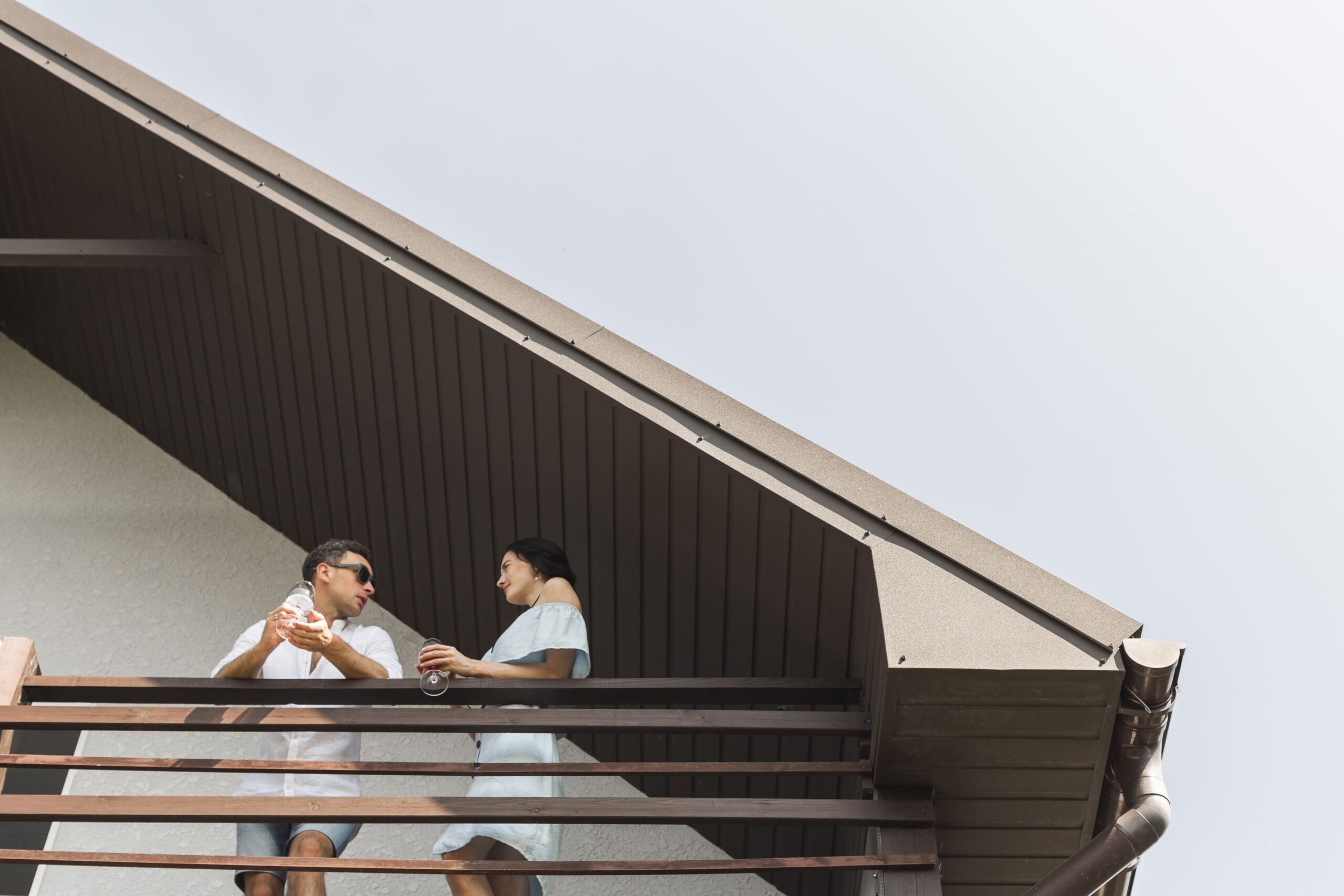 Maximise Loft Space in Semi-Detached Homes with a Custom Hip to Gable Loft Conversion Solution 1 low angle view couple standing balcony 1 1 scaled