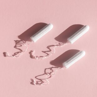 menstrual tampons with thread pink background 1
