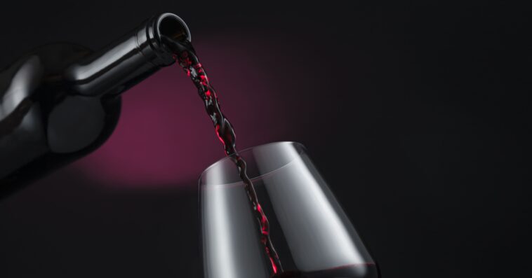 bottle red wine poured into wine glass 1