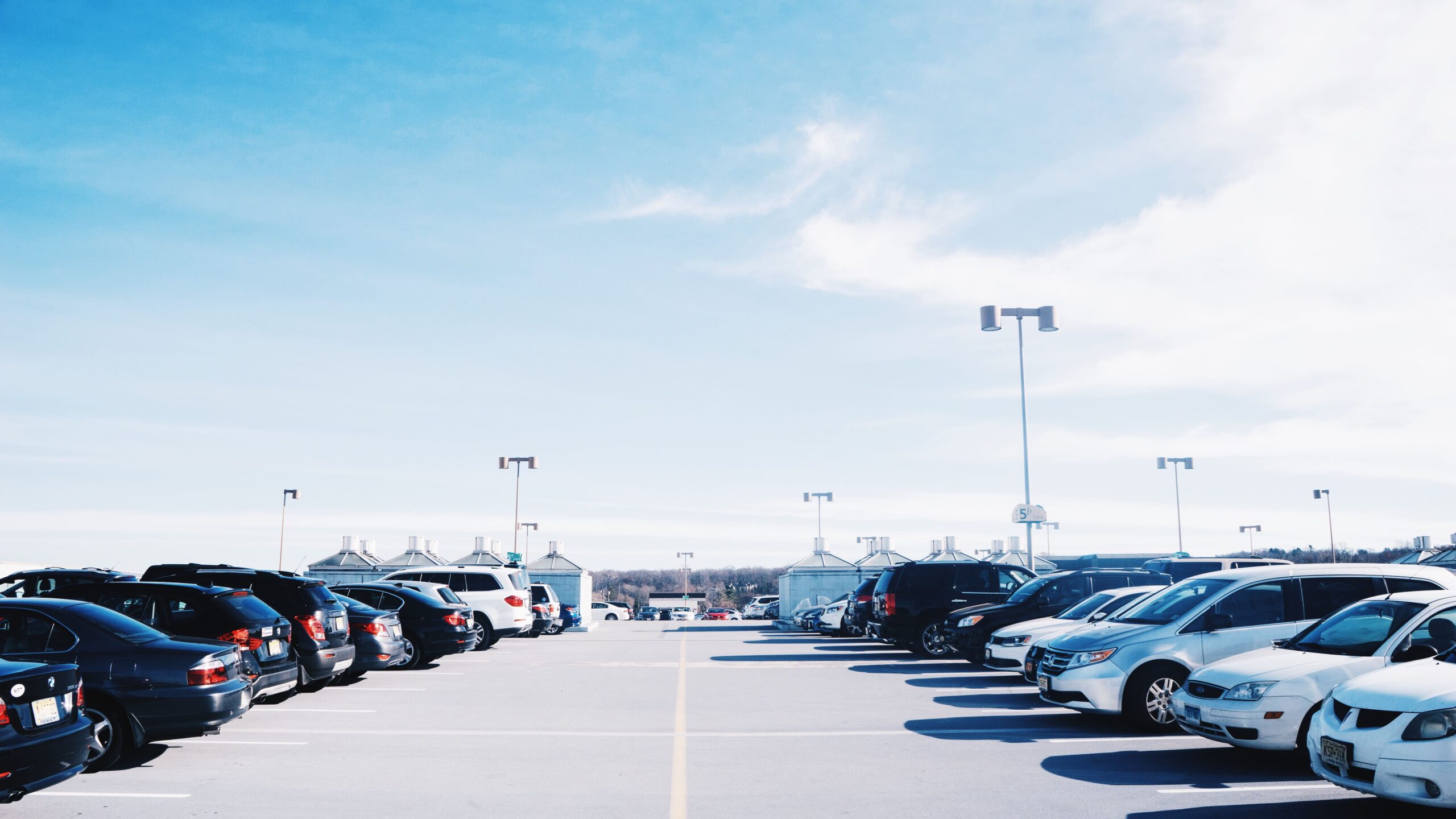 cars parked parking lot against sky 1 scaled