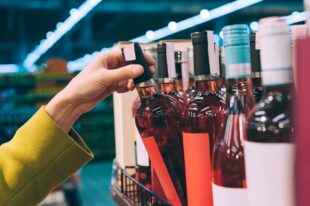 girl holds bottle wine store 1
