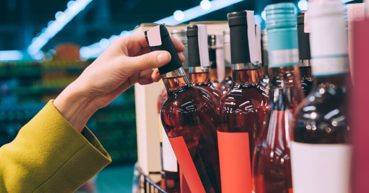 girl holds bottle wine store 1