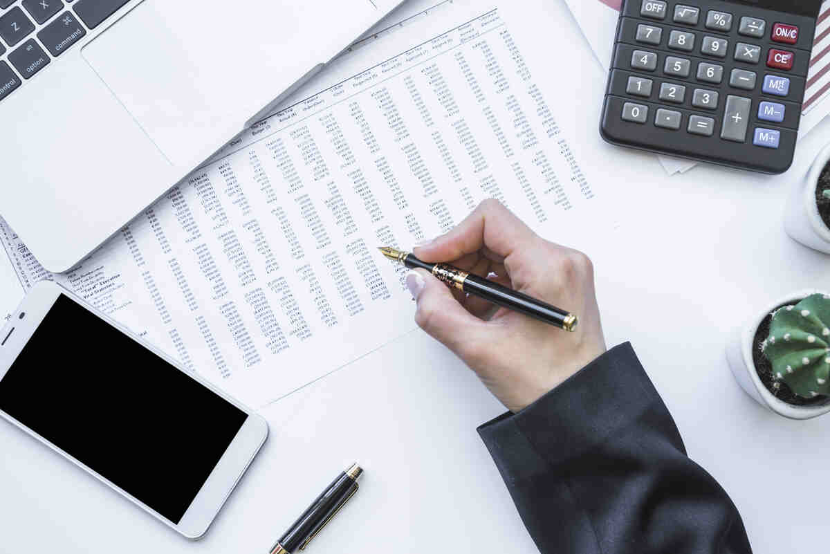 Small Business Bookkeeping: A Beginner’s Guide (2025) 1 hand holding fountain pen office desk 1