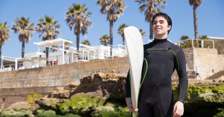 happy handsome young man holding surfboard sunny beach 1