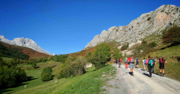 hikers walking through pathway surrounded by hills covered greenery sunlight 1 1 1
