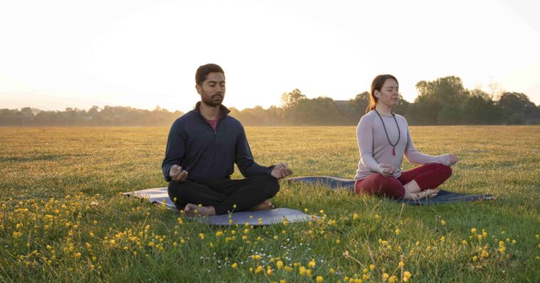 man woman doing yoga together outdoors 1 1