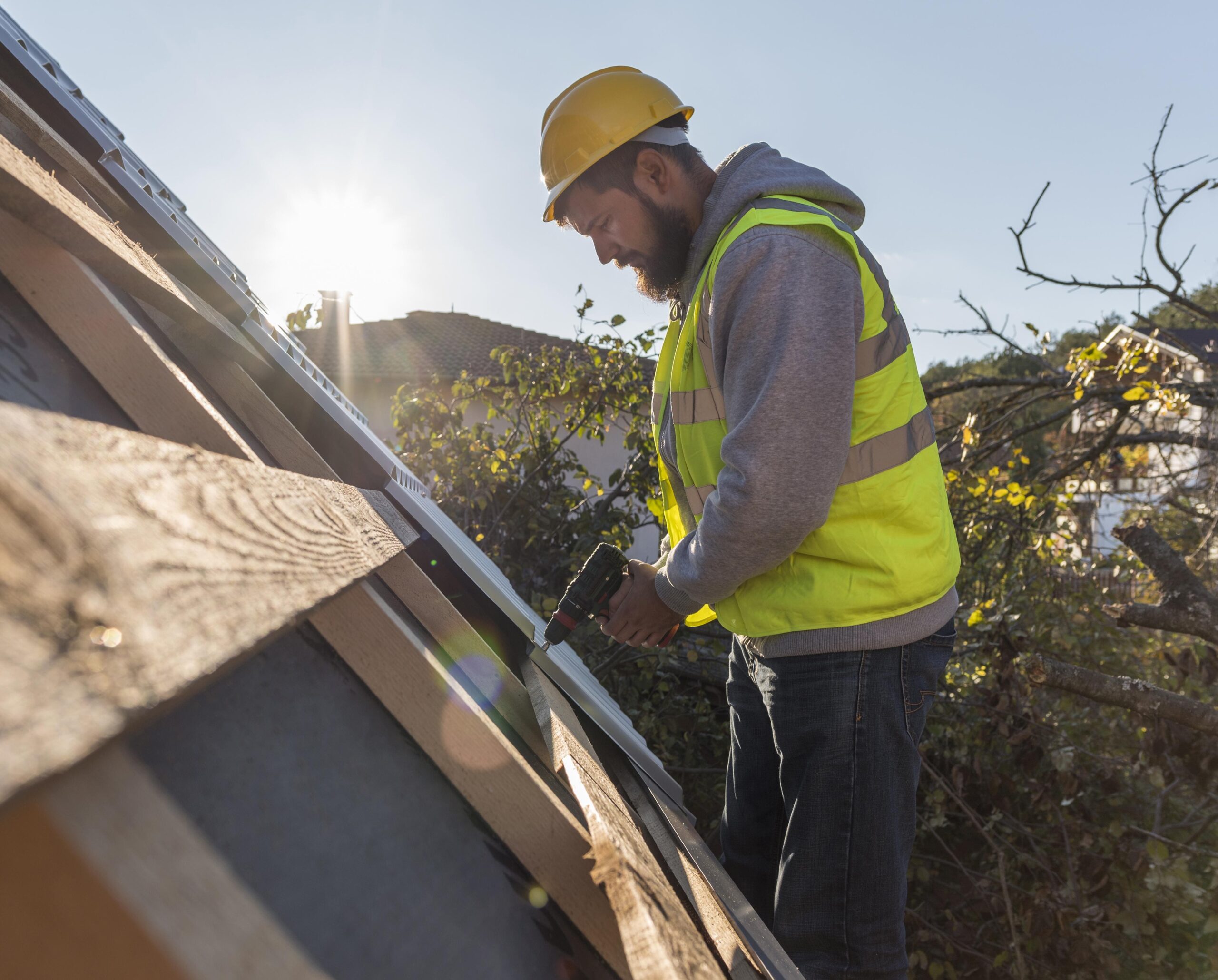 Reliable London Roof Repairs? 1 man working roof with drill 1 scaled