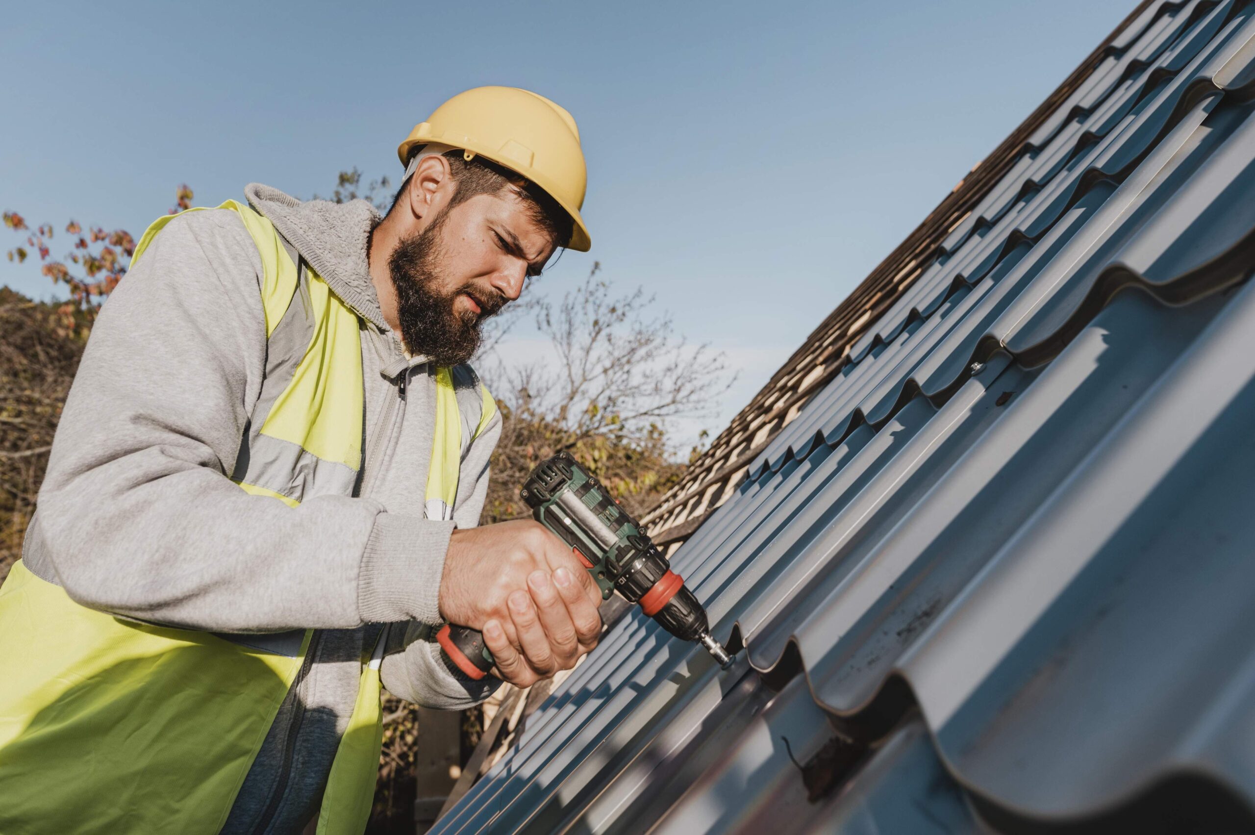 Quick & Reliable Roof Repair in London 1 sideways man working roof with drill 1 1 scaled
