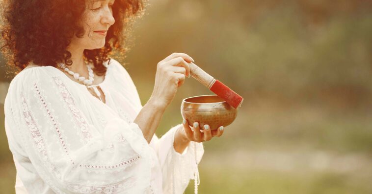 woman holding chanting bowl nature setting 1 1