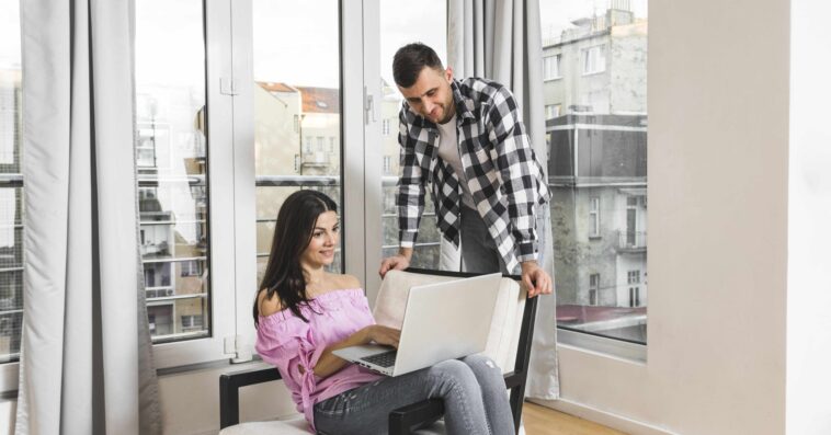 young man looking his girlfriend using laptop home 2 1 1 1