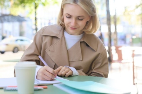portrait carefree blond cute woman working with documents drinking takeaway coffee sitting 1 1 1 1 1 1 1